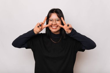 Kendinden geçmiş genç bir kadının portresi beyaz arka planda gözlerinin yanında iki tane Ziyaretçi hareketi tutuyor..