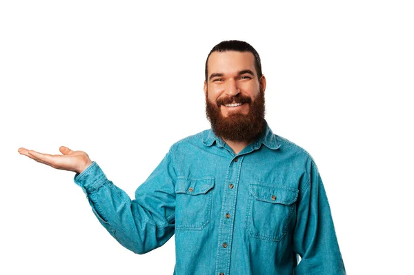 Senyum Ceria Pria Berjanggut Memegang Telapak Tangannya Menyajikan Sesuatu Studio — Stok Foto