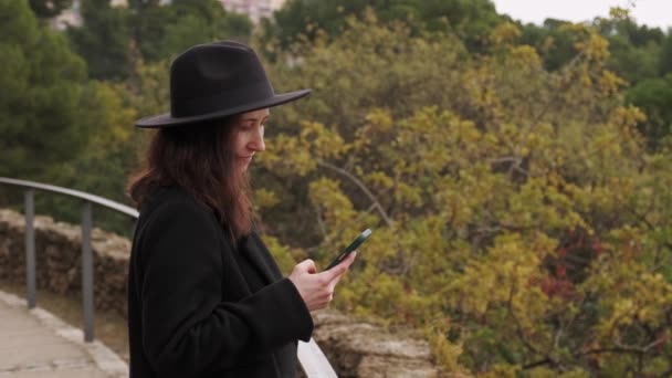 Молода Елегантна Жінка Чорному Пальто Капелюсі Робить Фотографії Своїм Телефоном — стокове відео