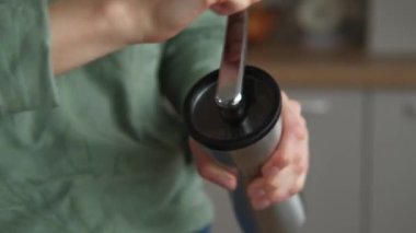 Kadının mutfakta öğütücüyle kahve öğüttüğü videoyu kapat..