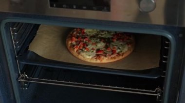 Pizzayı elektrikli fırından çıkaran kadının videosu..