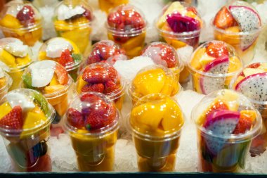 Dilimlenmiş egzotik meyvelerle dolu bir bardak..