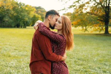 Gün batımında doğada kucaklaşan genç çift.