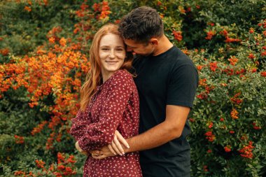 Doğada kucaklaşan genç ve şirin bir çiftin portresi..