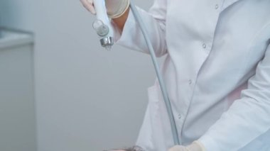 Kozmetikçinin ürün serumuyla cilde nüfuz eden yaşlanmayı önleyici kozmetik cihaz prosedürünü kullandığı görüntüler.