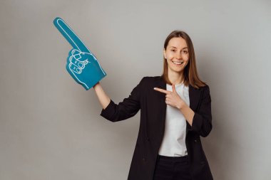 Vantilatör eldiveni giymiş kameraman kıza gülümsemek iki elini de gri arka planda tutmak demektir..