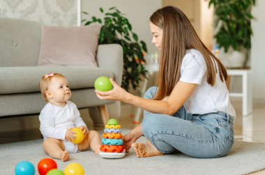 Küçük kız, oyun oynarken ve renkleri öğrenirken annesiyle iyi vakit geçiriyor..