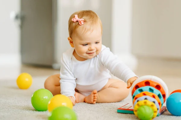 Concentrado Bonito Bebê Menina Está Brincando Com Seus Brinquedos Coloridos Imagem De Stock