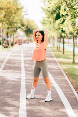 Spor yapan kadının dikey görüntüsü sabah esneme hareketlerini yapıyor..