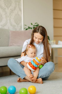 Yavru kızıyla evde oynayan genç bir annenin dikey çekimi..
