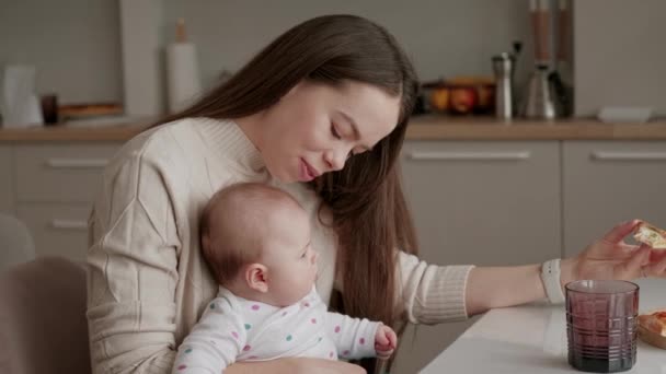 Filmagem Jovem Mãe Sentada Com Sua Menina Cozinha Comendo Fatia — Vídeo de Stock