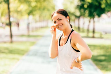 Yakışıklı orta yaşlı sporcu kadın kulaklıklarıyla güzel bir müzikle koşmaya hazırlanıyor..