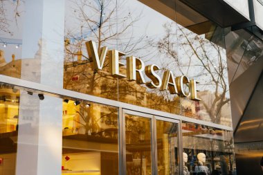 21 Şubat 2023, İspanya, Barselona. Barcelona sokaklarının girişindeki dükkanın camında Versace logosu var..