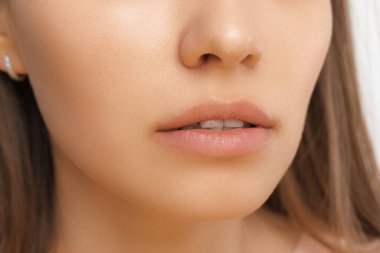 Genç, sağlıklı, temiz, ince dudaklı ve derili bir kadının stüdyo fotoğrafını çek..