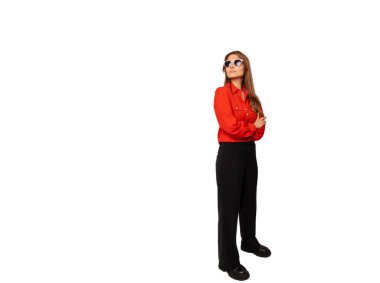 Kırmızı tişörtlü, güneş gözlüklü, kollarını kavuşturmuş ciddi bir genç kadının tüm vücudu..