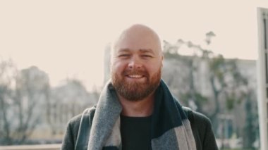 Dışarıdaki kameraya gülümseyen genç sakallı adamın videosunu kapat..