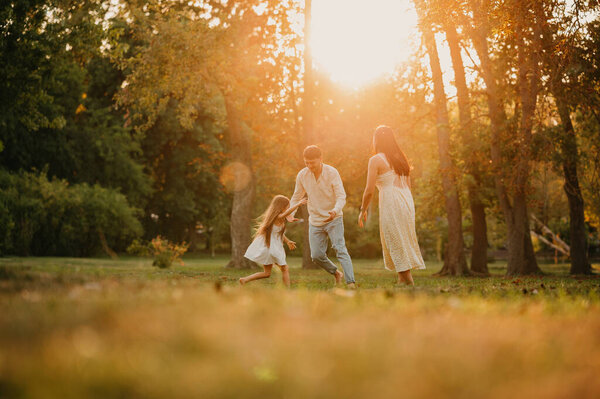 Сказка о счастливой семье, играющей в парке в солнечный день.