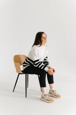 Bir kadının beyaz bir stüdyoda sandalyede otururken iyi vakit geçirdiği uzun bir çekim..