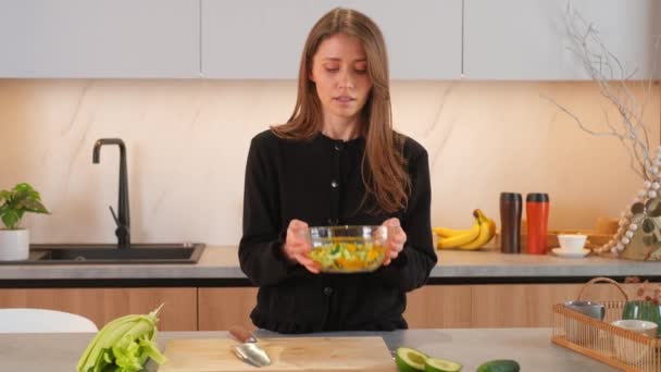 ボウルにスライスされた野菜を混合する若い女性の映像 — ストック動画