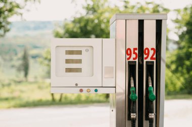 Güneşli bir günde 95 ve 92 oktanlı benzin istasyonunda yakıt ikmali sunan bir benzin pompası.