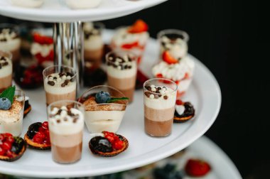 Zarif tatlı büfesi vitrininde cam bardaklarda çeşitli lezzetli ve renkli tatlılar sergileniyor..