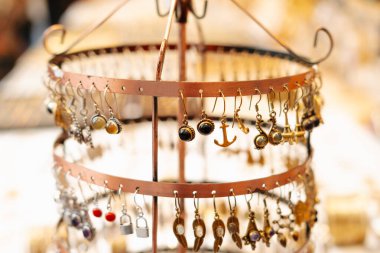 Değişen bir mücevher tezgahında sergilenen çeşitli küpelerin yakın çekim görüntüleri, güzelce düzenlenmiş..