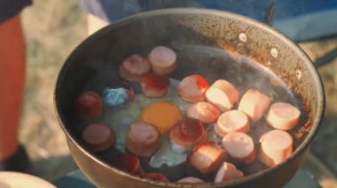 Açık havada pişen sosis ve yumurta yakın plan, kamp ve açık hava aktiviteleri için mükemmel..