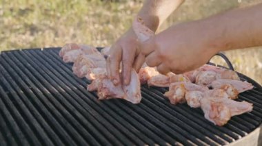 Sulu tavuk kanatları harika bir açık hava barbekü deneyimi için ustalıkla terbiye ediliyor ve ızgara ediliyor.