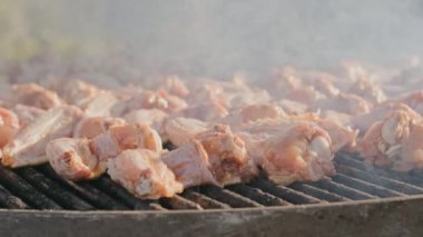 Lezzetli ve mükemmel ızgara tavuk kanatları ızgarada pişiyor, enfes dumanlı tatlar yayıyor.