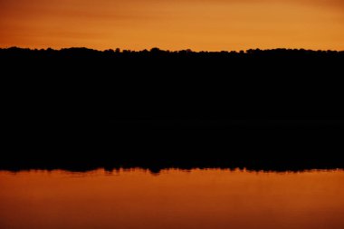 Sersemletici bir günbatımı, durgun sulara yansıyan ılık bir parıltı yayar. Barış ve güzellik arayan doğa aşıkları için idealdir.