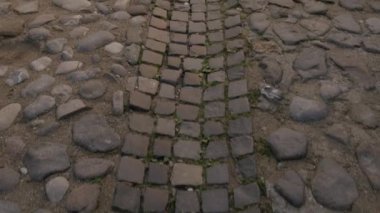 Büyüleyici ve pitoresk bir kaldırım taşı yolu, yemyeşil doğal elementlerin arasına kurulmuş, eşsiz kırsal cazibe sergiliyor.