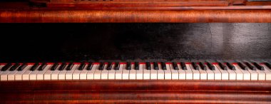 Büyük bir piyano klavyesinin çarpıcı yakın plan görüntüsü zamansız klasik tasarımını güzel bir şekilde sergiliyor.