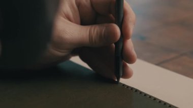 Kağıt üzerinde güzel sanatlar yaratmak, yaratıcılık ve zanaatkarlık sergilemek için kalem kullanan eller.