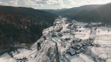 Nefes kesici dağların arasına kurulmuş, karla kaplı, nefes kesici bir köyün nefes kesici hava manzarasını ele alalım.