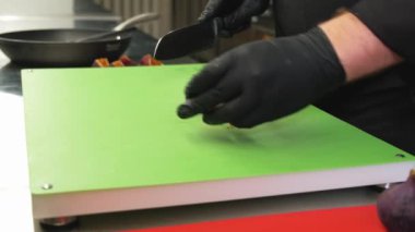 Yetenekli bir şef, canlı ve renkli bir mutfak ortamında taze, olgun incirleri ustaca dilimliyor.