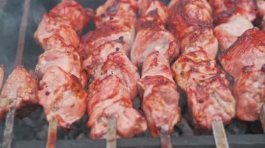 Cızırdayan ve ağız sulandıran et şişleri açık hava barbekü düzeninde mükemmel ızgara yapıyorlar.