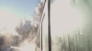 Donmuş pencereleri ve sisli çevresiyle nefes kesici kış manzarasında seyahat eden bir trenin resimsel görüntüsü.
