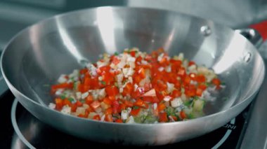 Renkli sebzelerin canlı bir karışımı sağlıklı bir yemek için mükemmel paslanmaz çelik bir tavada cızırdıyor.