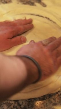 Becerikli ellerin hamuru ustalıkla yoğurması, güzel bir şekilde karmaşık pişirme sanatını gözler önüne sermesi.