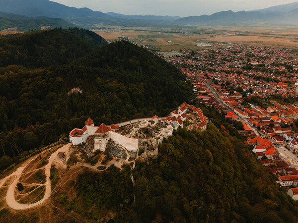 Цетатея Раснова. Эта воздушная съемка показывает исторический замок на склоне холма рядом с оживленным городом, окруженный величественными горами