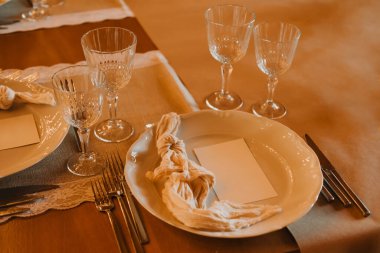 Nefis cam eşyalar, ince tabaklar ve istisnai yemek için detaylı peçeteler ile güzelce düzenlenmiş bir masa.