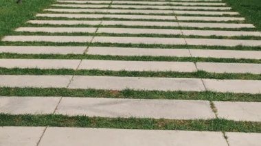 Bu şık yürüyüş yolu yeşil çimenlerin ve dayanıklı taşın alternatif bölümlerine sahiptir. Açık alanları geliştirmek için idealdir.