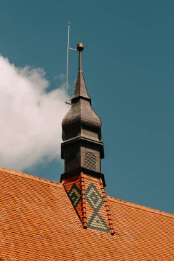 Güzel ve pitoresk bir kilise kulesi. Karmaşık tasarım elementleri açık mavi gökyüzüne karşı duruyor.