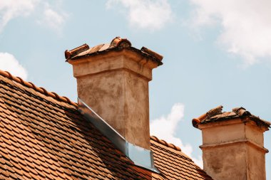 İki eşsiz ve ayırt edici baca gururla fayanslı bir çatı üzerinde duruyor, kabarık bulutların üzerine kurulmuş.