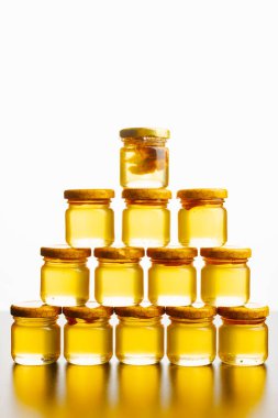 Çok güzel düzenlenmiş bir bal kavanozu gösterisi. İçlerindeki balın zengin, doğal altın rengini sergiliyor.