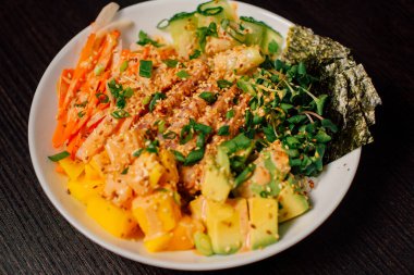 Taze sebzeler, meyveler ve lezzetli soslar içeren lezzetli ve canlı bir vejetaryen kasesi. Afiyet olsun