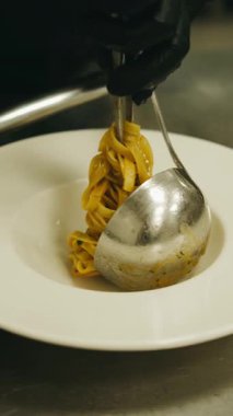 Yetenekli bir şef fettuccine makarnası, inanılmaz bir mutfak sanatı ve sunumu sergiliyor.