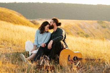 Geniş bir altın tarlada, sevgi, kahkaha ve müziği paylaşan bir çiftin güzel romantik anı.