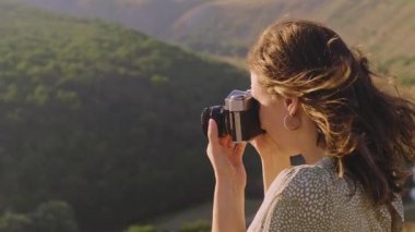 Genç bir kadın neşeyle nefes kesen bir manzara yakalıyor, etrafındaki yaratıcılığı ve macerayı tamamen kucaklıyor.