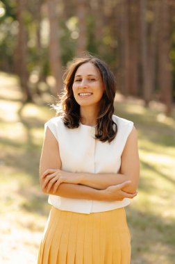 Bir kadın sakin ve güzel bir doğal ortamda kendine güvenerek duruyor. Zarafet ve huzur sergiliyor.